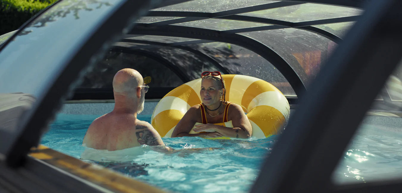 Ingela och Peter badar i pool under pooltak